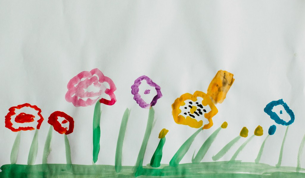 Child’s watercolor painting of colorful flowers on white paper